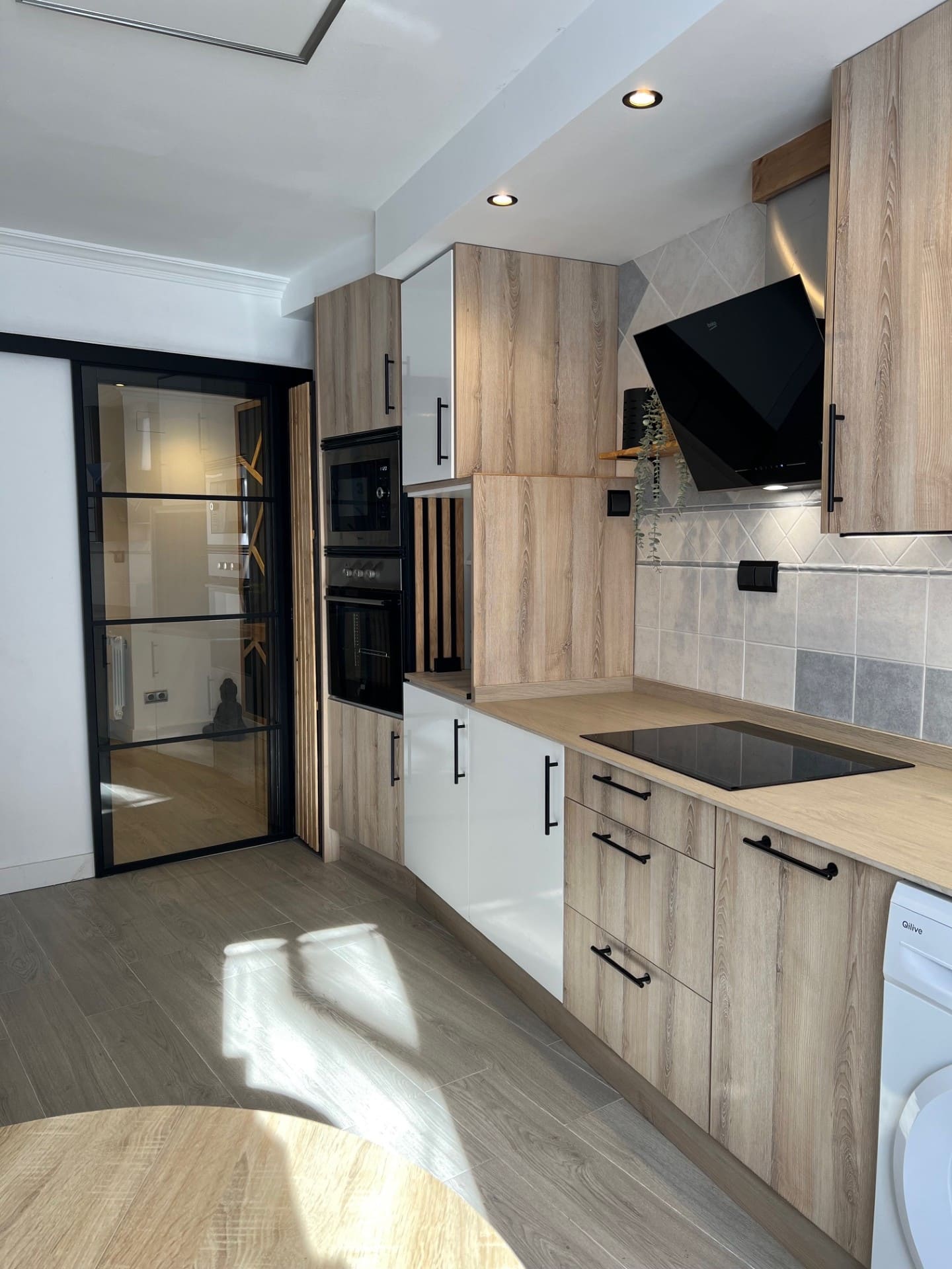 Después: Cocina con muebles de madera clara y electrodomésticos integrados. Antes: cocina en obra.
