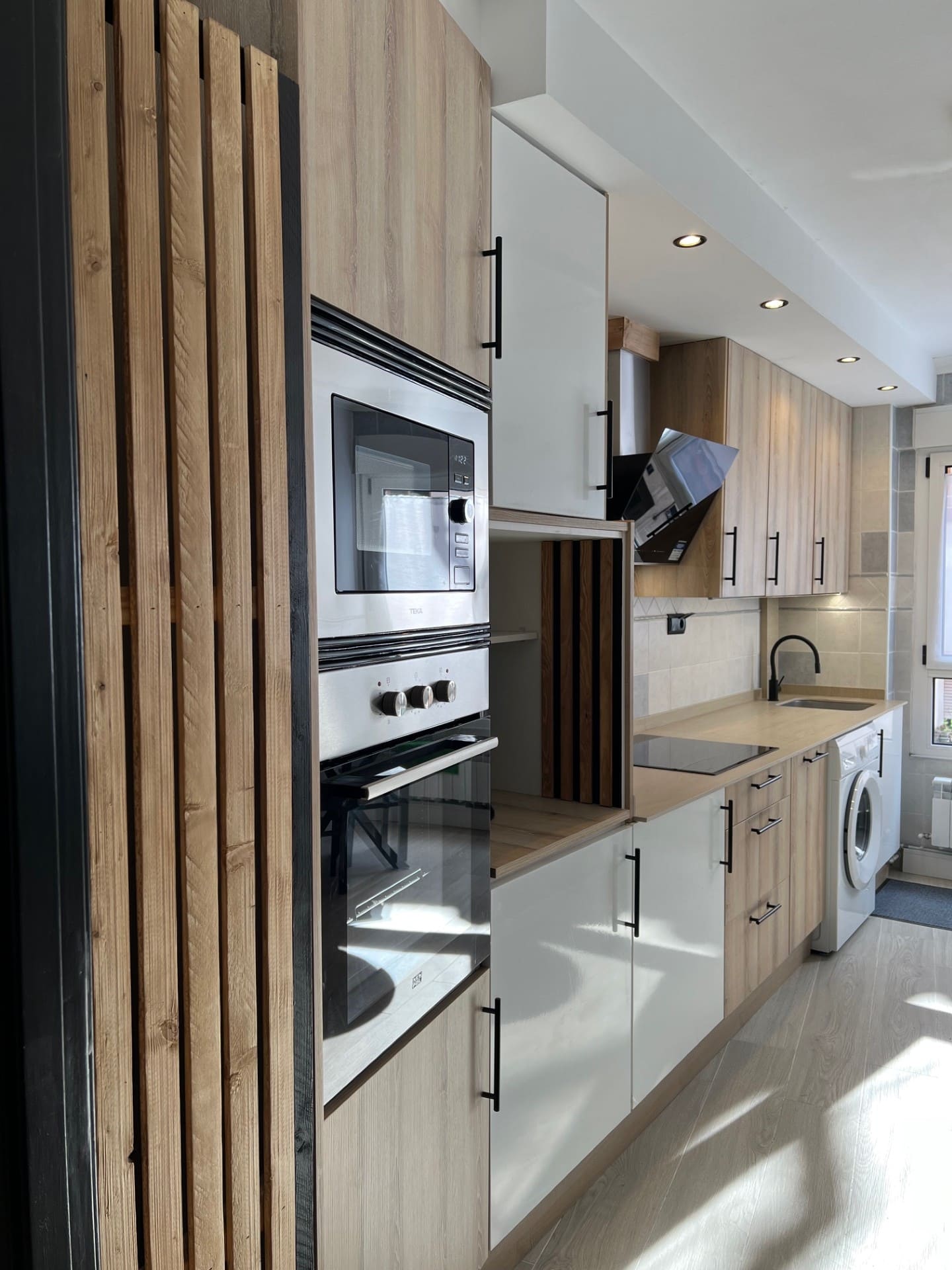 Después: Cocina con muebles de madera y lamas decorativas. Antes: estancia vacía en obra.